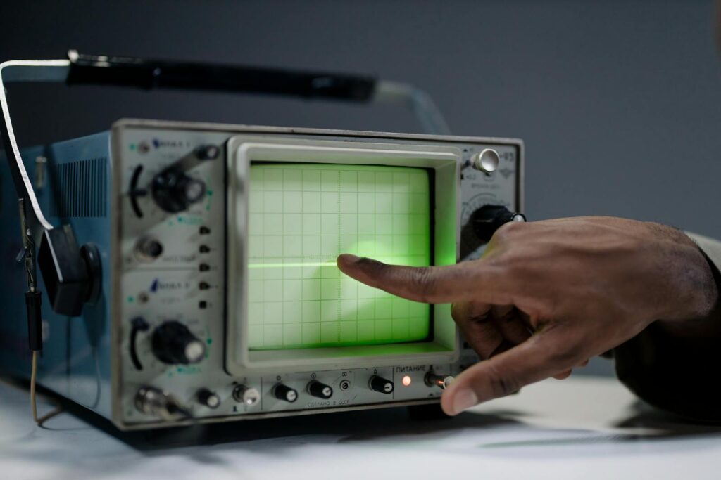 Close-up of Man Pointing at the Screen of a Oscilloscope