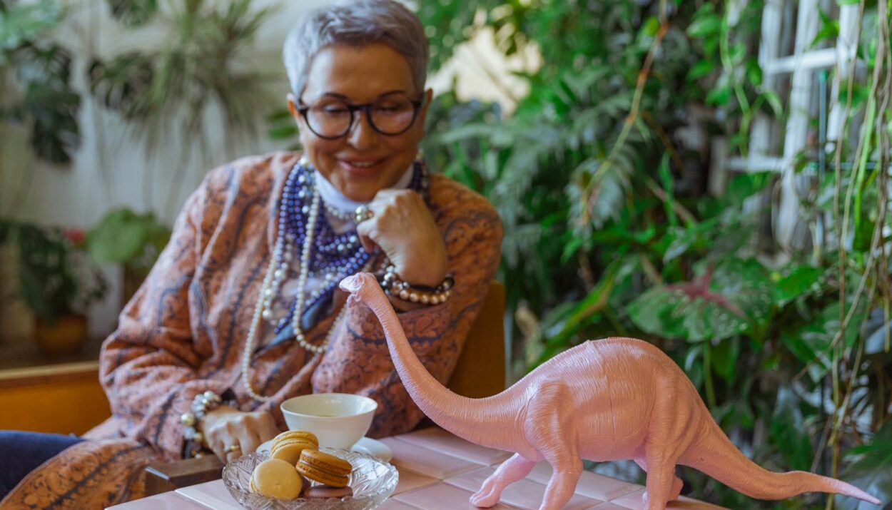Photo of Eldelry Woman Looking at a Dinosour Miniature